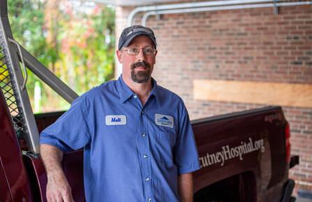Mark Martaniuk standing by work truck
