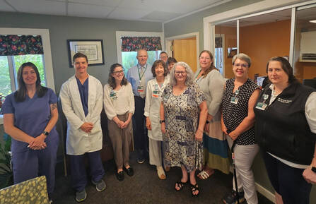 Dawn Paczkowski (center of picture) posing with fellow staff in office.