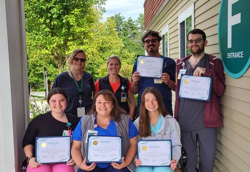 A group of people stand outside of Mt. Ascutney Hospital and Health Center holding certificates.